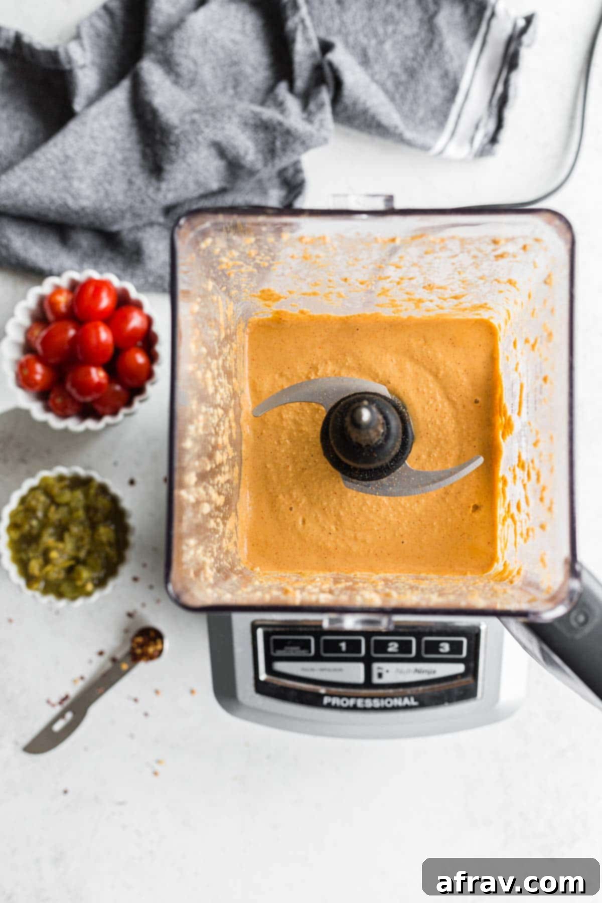 Overhead view of vegan queso blended together in a stand blender, showcasing its smooth texture.