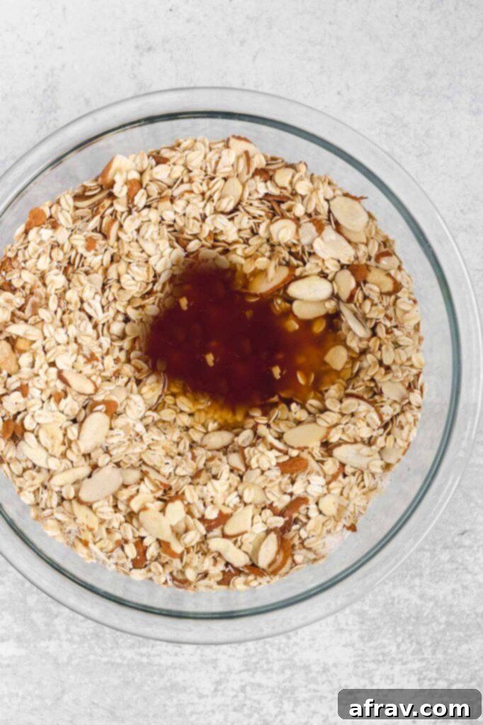 Wet ingredients for oat and honey granola, including honey, coconut oil, and vanilla extract, ready to be mixed with dry ingredients.