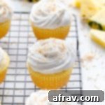 Pineapple coconut cupcakes arranged on a wire rack.