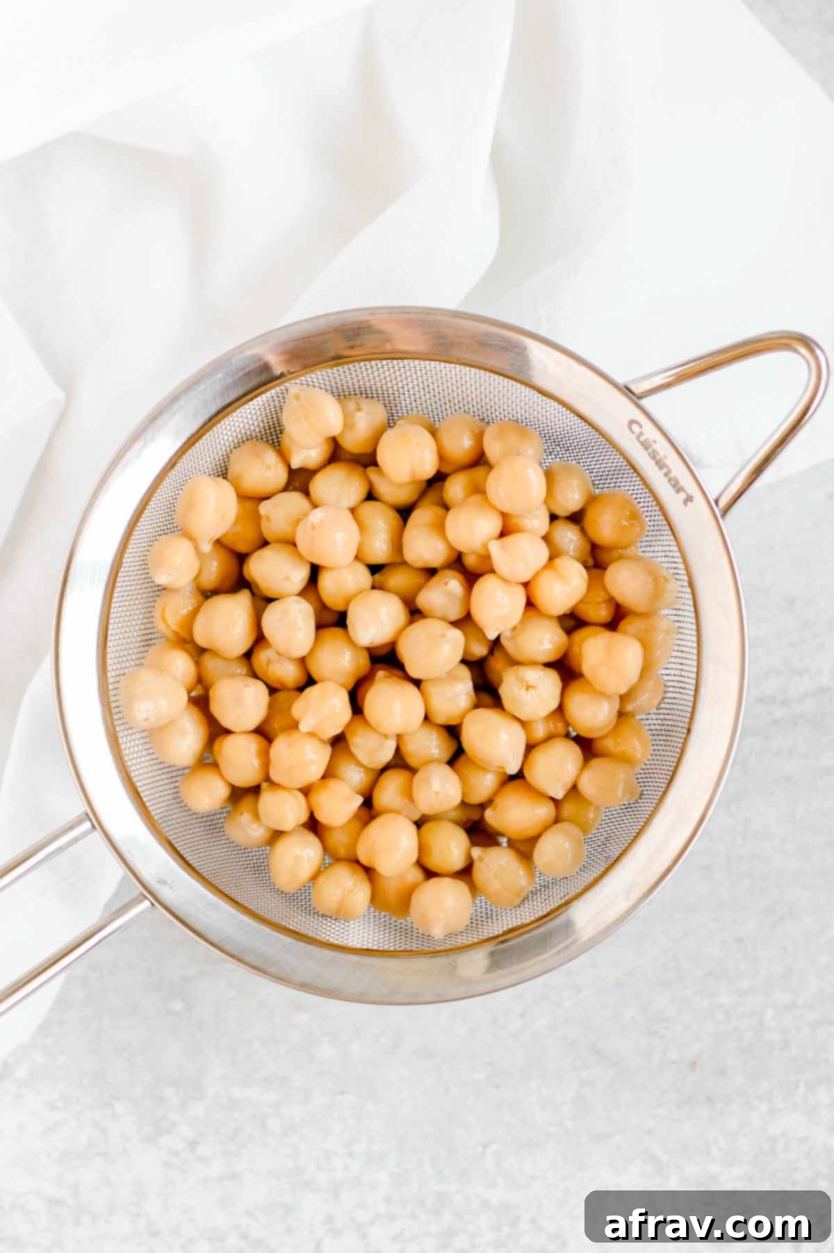 Drained chickpeas in a stainless steel colander.
