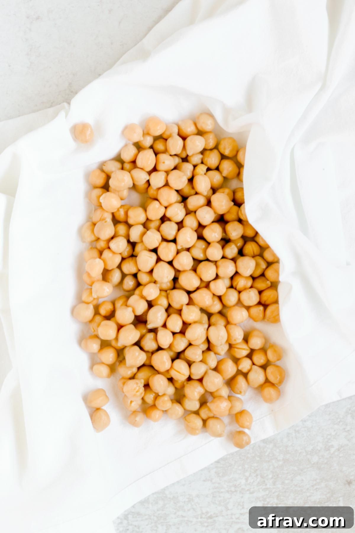 Chickpeas drying in a white flour sack towel.