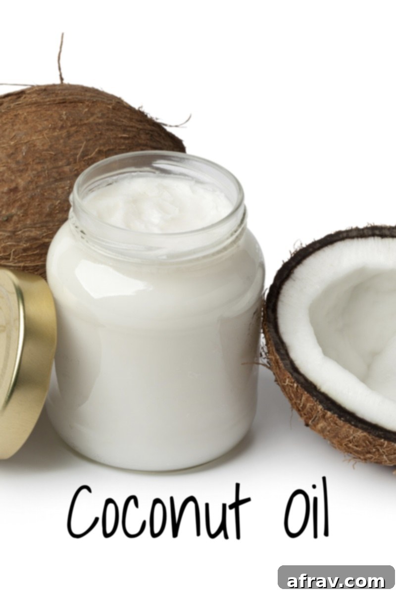 jar of coconut oil with two coconuts next to it, symbolizing its natural origin