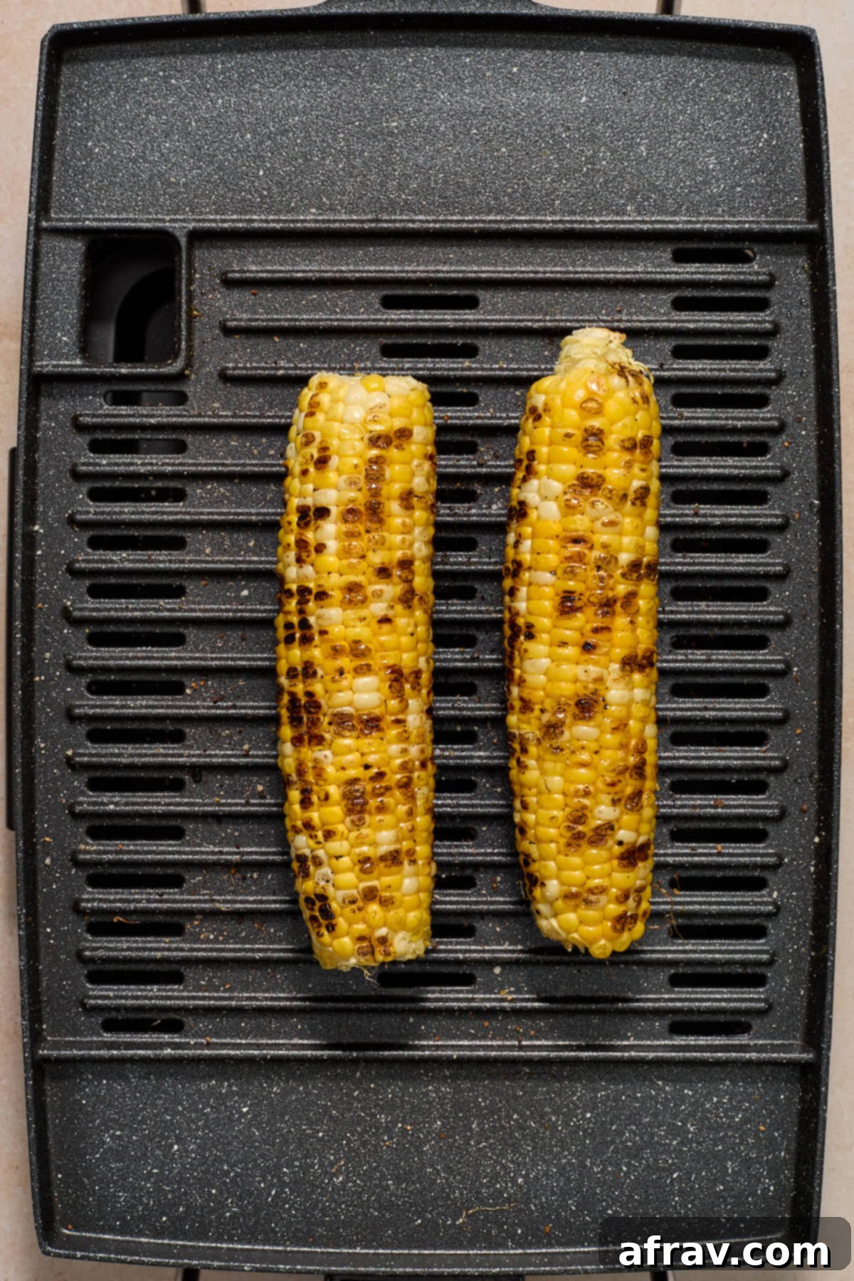 Charred Vegetable and Peach Orzo Summer Salad 6 Charred ears of corn on a grill.