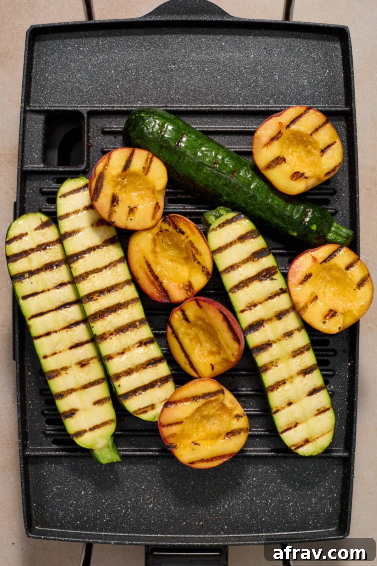 Charred Vegetable and Peach Orzo Summer Salad 7 Grilled zucchini and peaches on a grill.