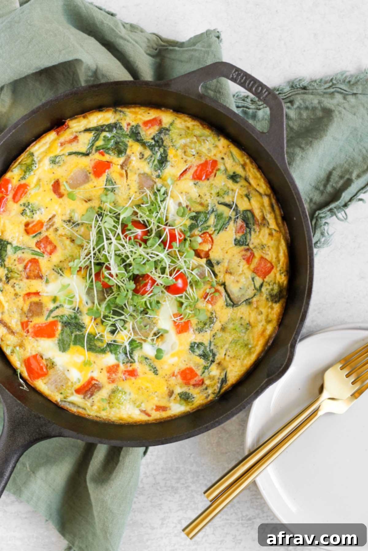 Dairy-free frittata topped with microgreens in a cast iron skillet.