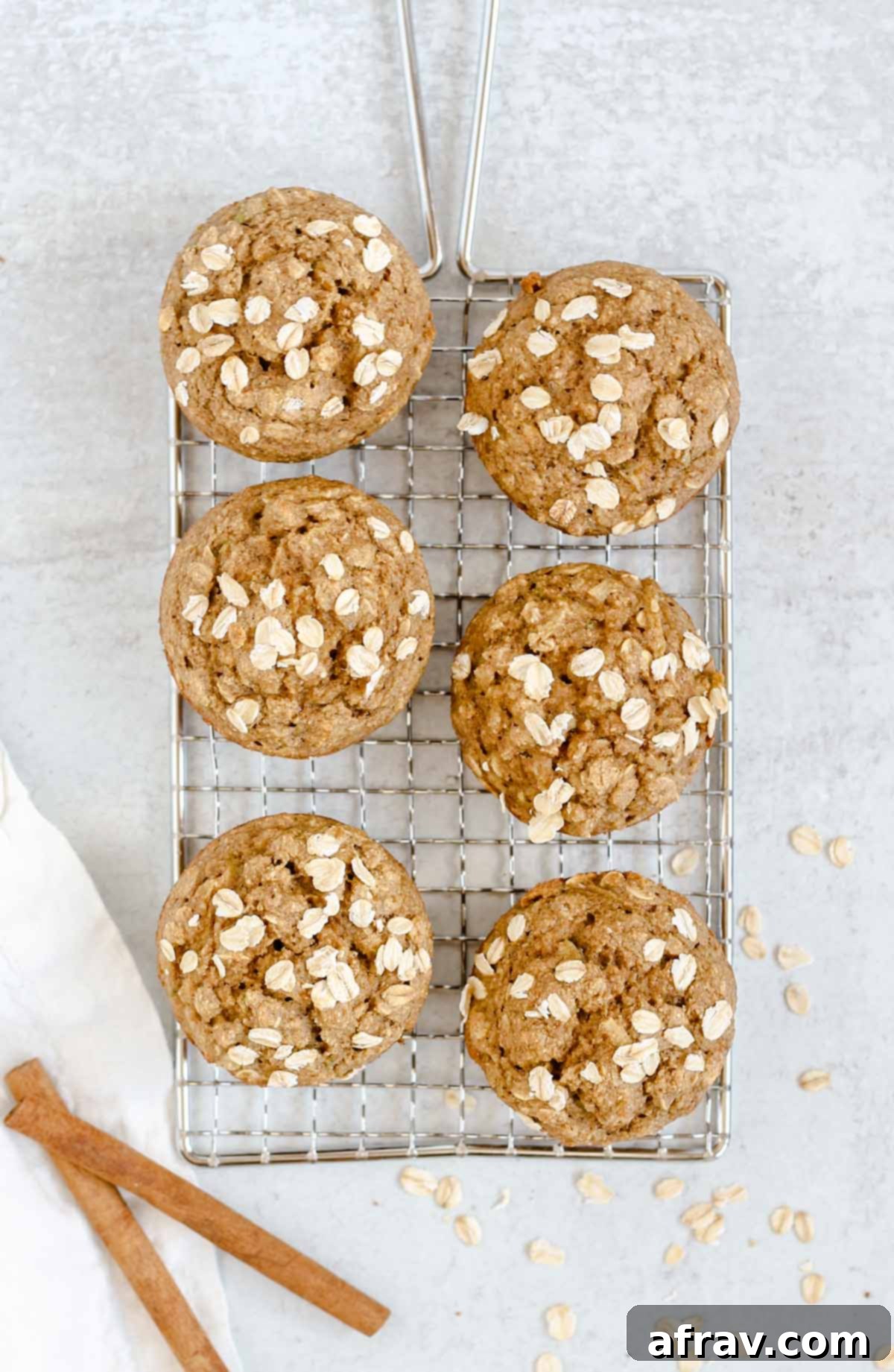 Freshly baked gluten-free apple cinnamon oat flour muffins cooling on a wire rack, ready to be enjoyed.