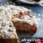 Side view of a slice of lemon raspberry almond crumb cake on a round pan.