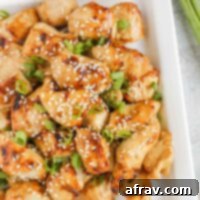 Pieces of air fried teriyaki chicken on a white plate.