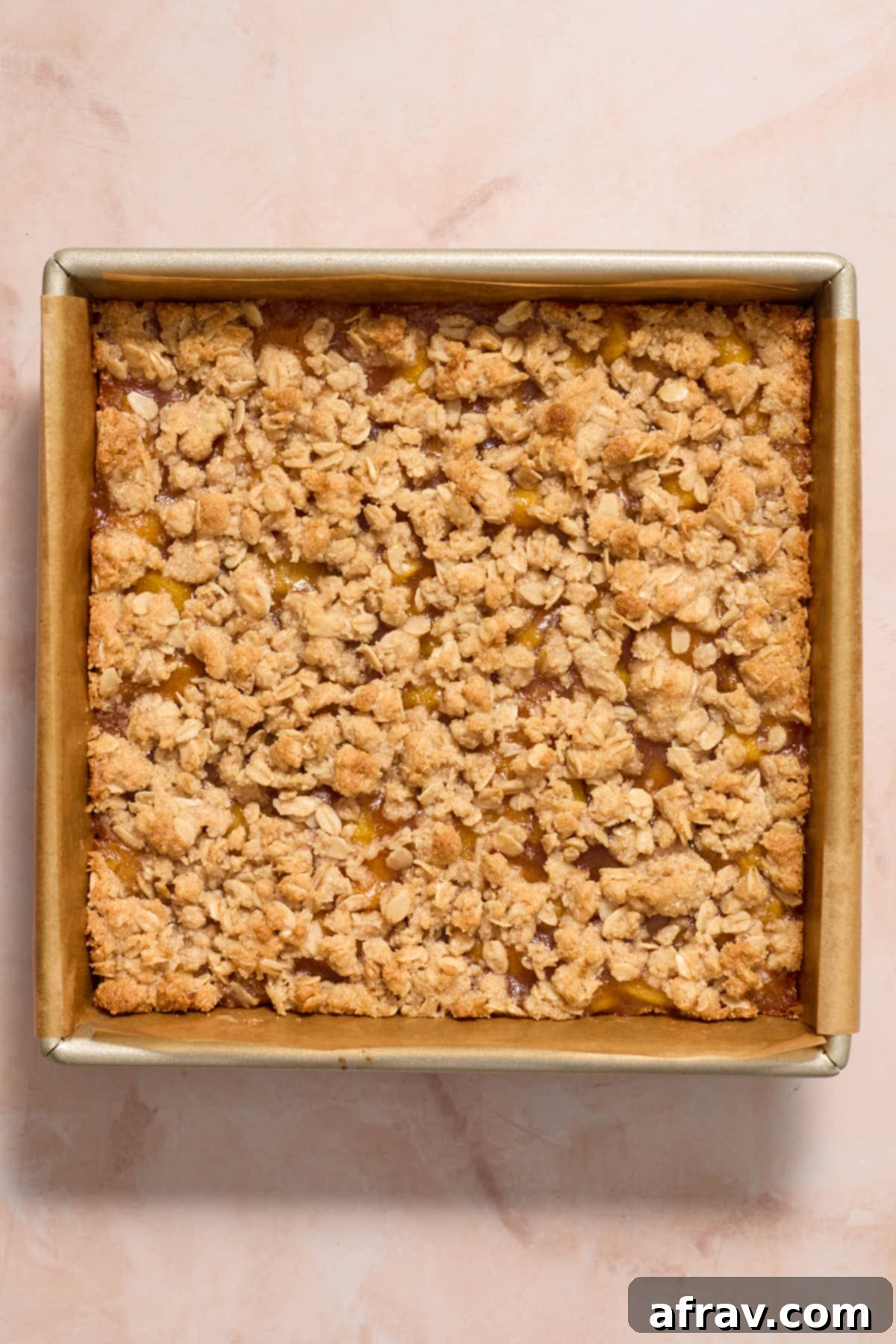 Baked peach crisp bars in the pan, golden brown and bubbling.