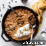 Overhead view of chocolate chip skillet cookie on a white surface.