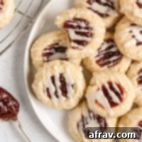 Gluten-free raspberry thumbprint cookies on a plate, with a festive feel.
