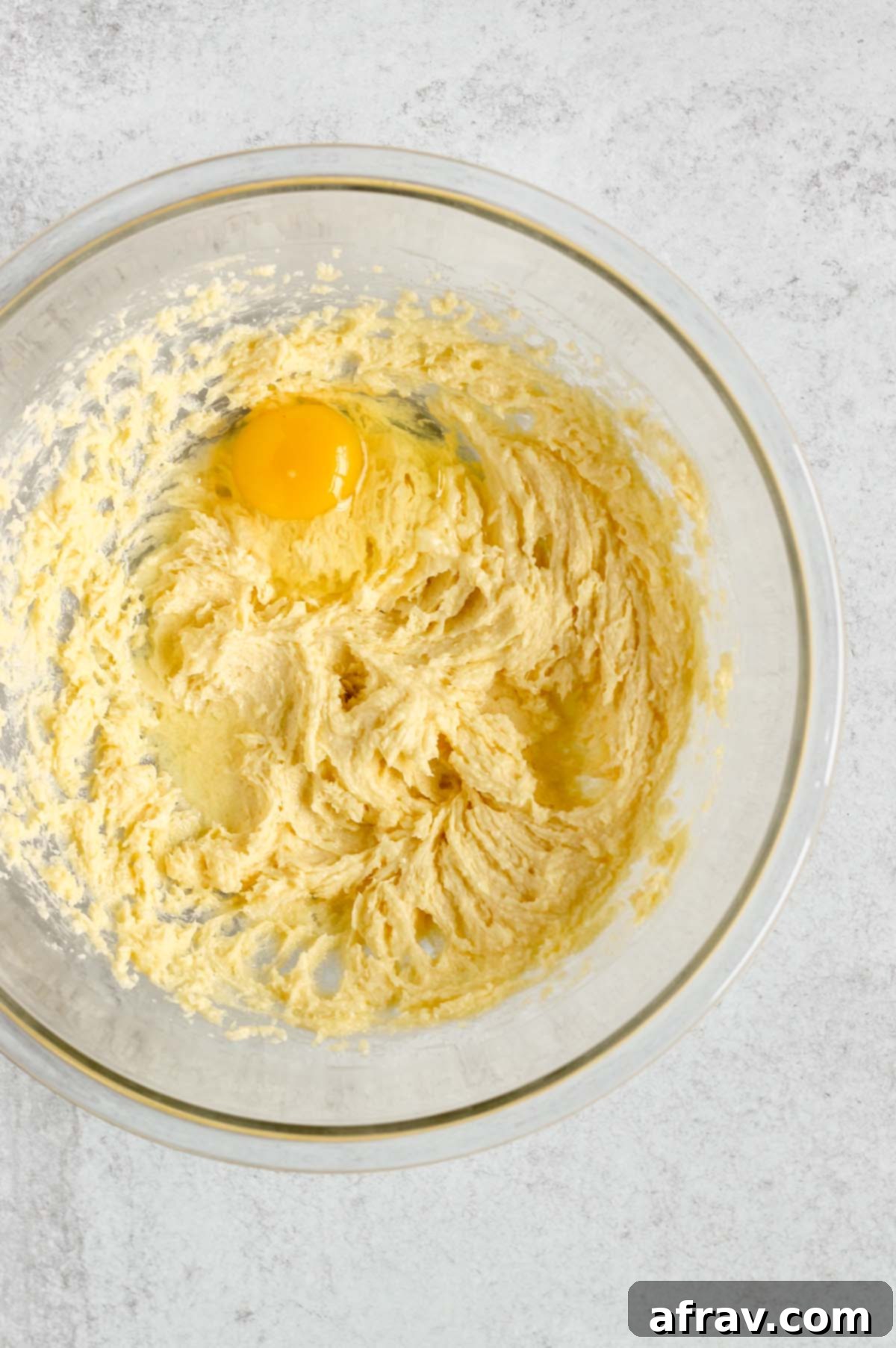 Creamed butter and sugar with an egg added, ready for mixing.