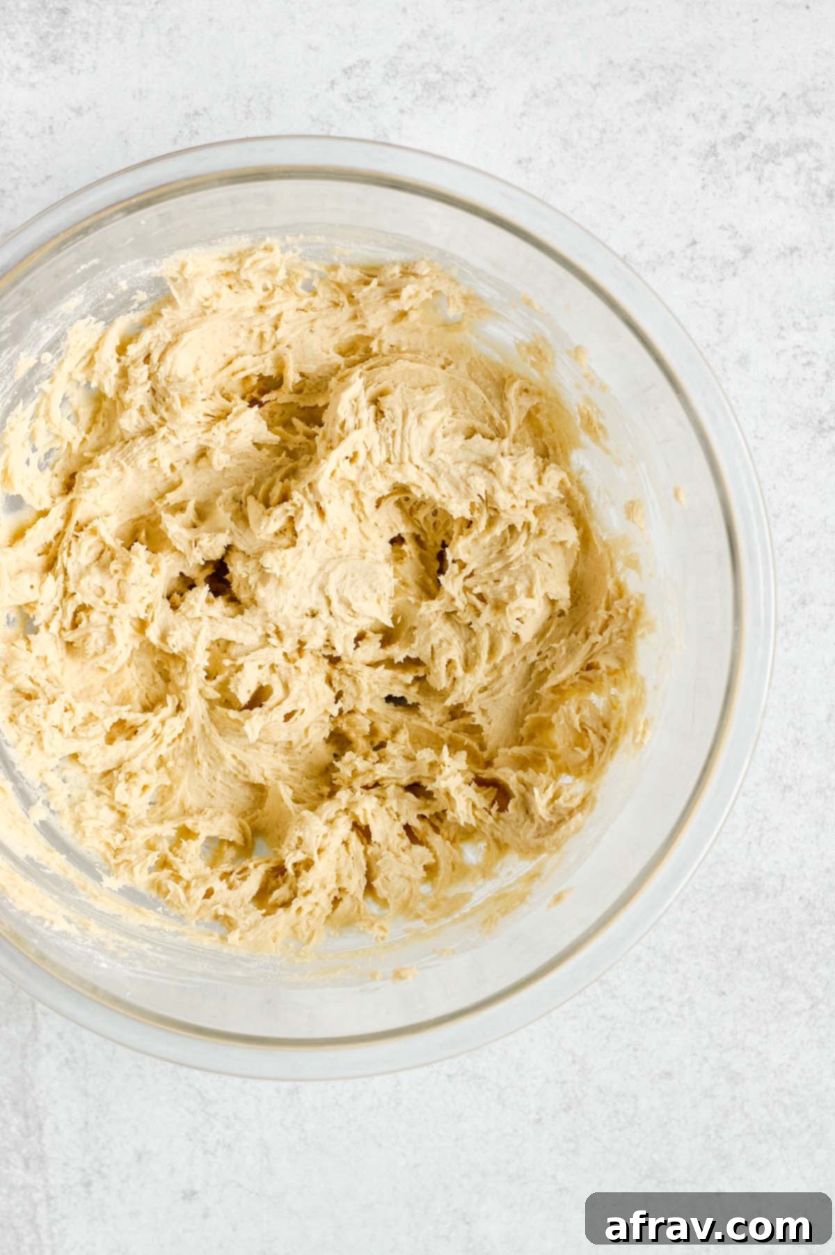 Thumbprint cookie dough fully mixed in a glass mixing bowl, showcasing its smooth texture.