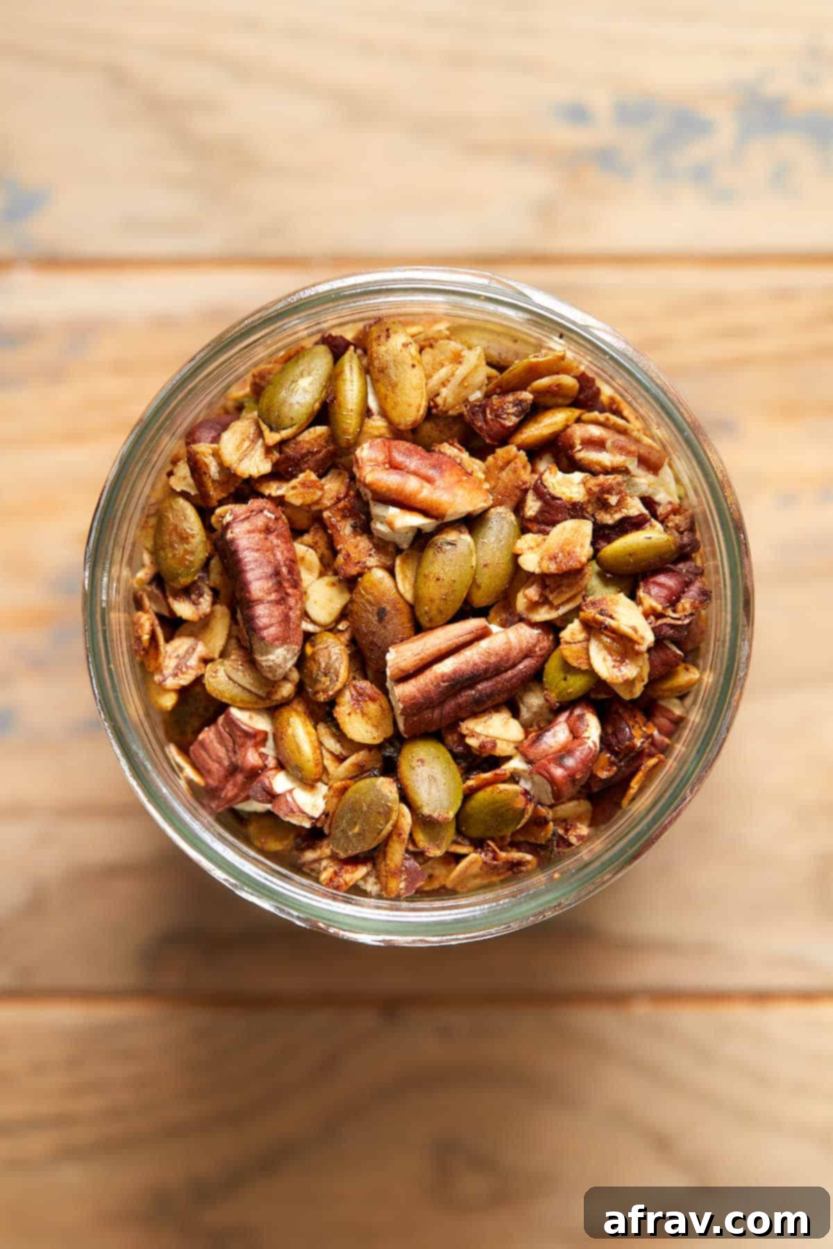 Robust Pecan Crunch Granola 2 Overhead view of savory granola in a glass jar, showcasing its crunchy texture and ingredients.
