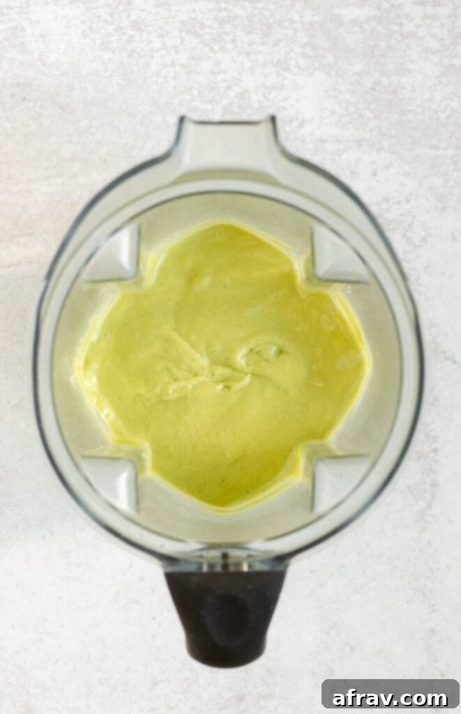 Smoothie blended in a blender, showing a smooth, vibrant green mixture.