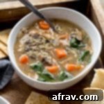 Instant Pot Chicken Wild Rice Soup in a white bowl arranged on a wooden serving tray.