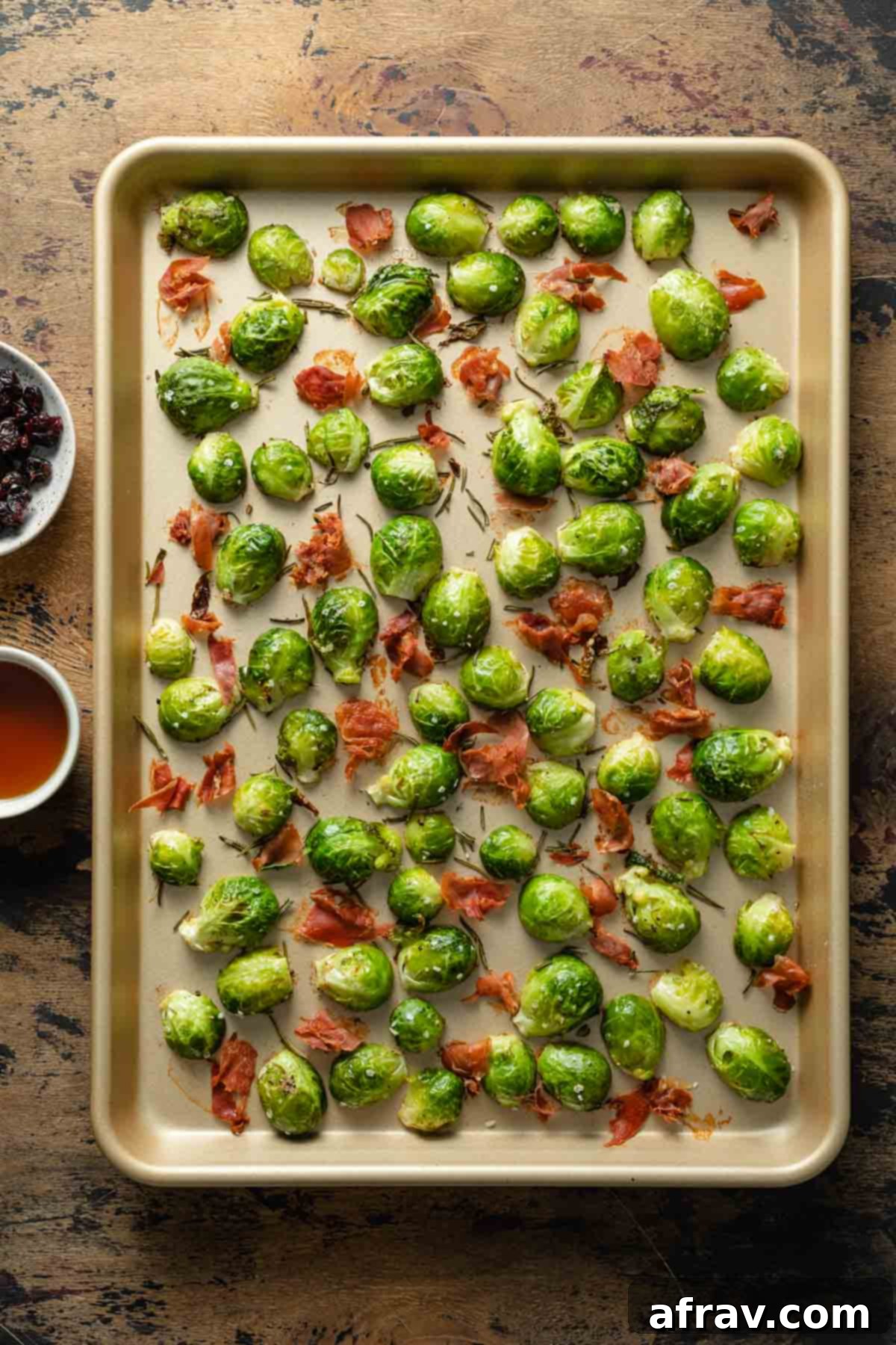 Roasted Brussels sprouts and prosciutto on a sheet pan, ready to be tossed.