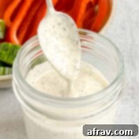 Effortless Dairy-Free Paleo Ranch Dressing 8 Spoon dripping with ranch dressing.