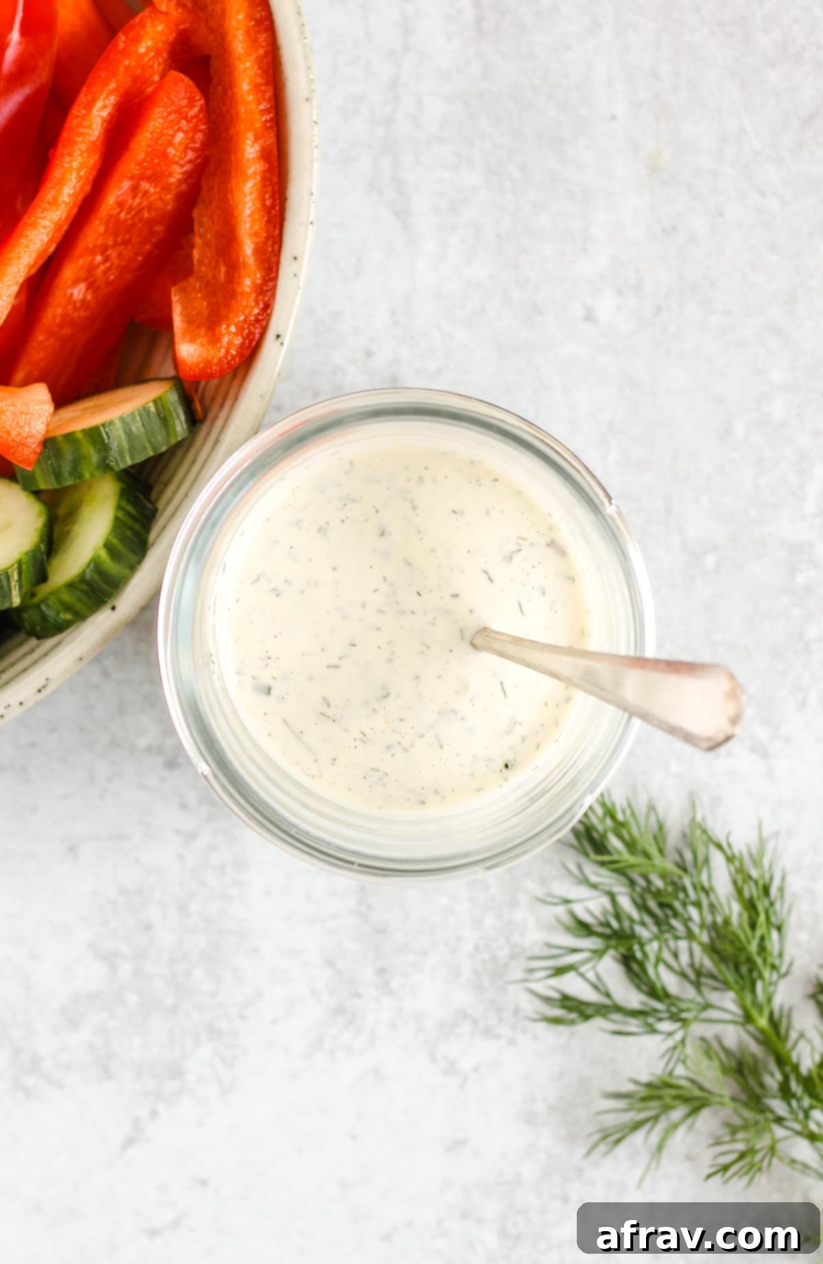 Effortless Dairy-Free Paleo Ranch Dressing 7 Overhead view of dairy-free ranch dressing in a mason jar with a spoon, ready to be enjoyed.