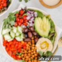 Mediterranean salad in shallow salad bowl with side of tahini dressing.