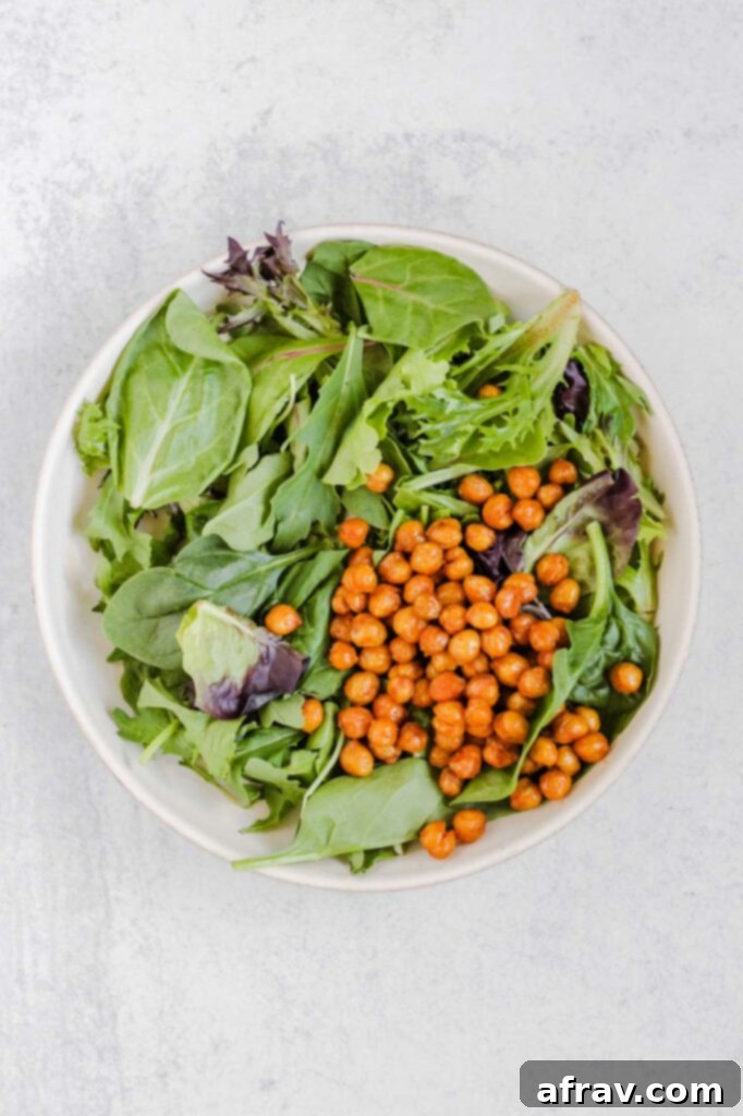 Mixed greens and roasted chickpeas in a salad bowl. 