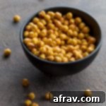 Air Fryer Chickpeas in a black bowl on a grey surface.