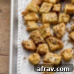 Cheesy Everything Bagel Croutons cooling on a baking sheet.
