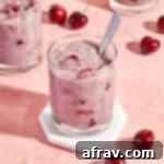 Delicious Dairy Free Gluten Free Cherry Chia Pudding 7 Cherry chia pudding served in a glass on a white coaster with a spoon inserted into the pudding.