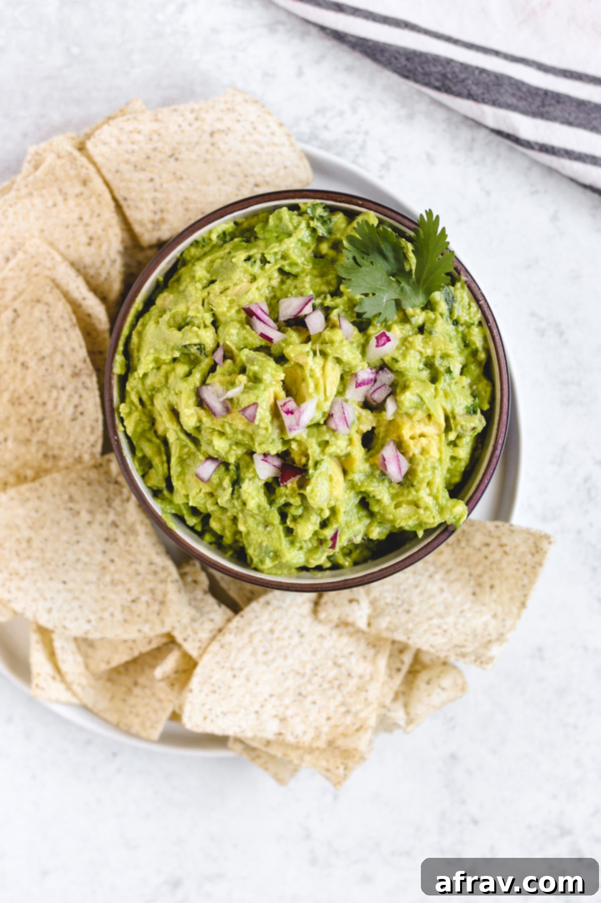 plate with chips and fresh guacamole in a bowl