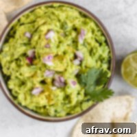 overhead view of guacamole in a serving bowl with chips sprinkled on the side
