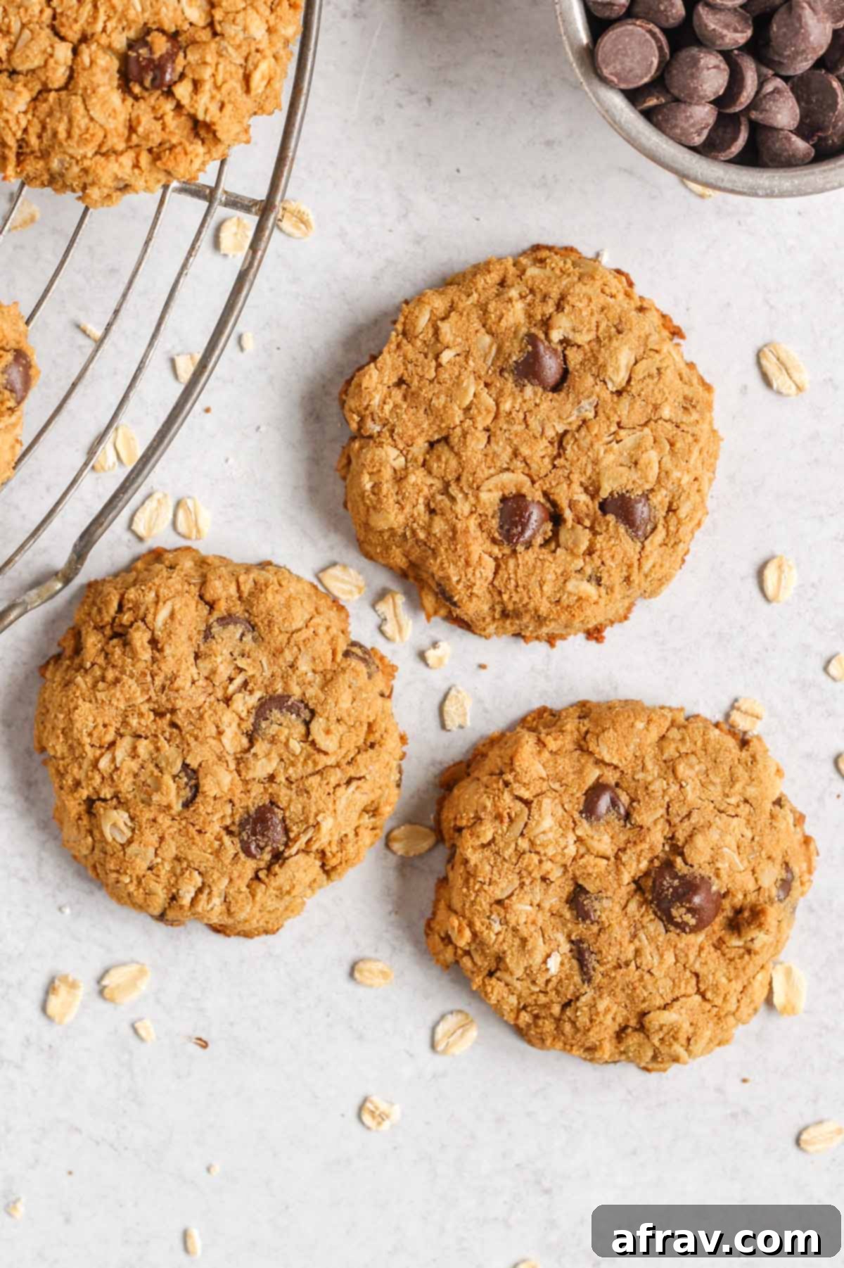 Effortless Coconut Flour Oatmeal Delights 8 Three oatmeal cookies with chocolate chips laid out flat on a surface, highlighting their delicious appearance.