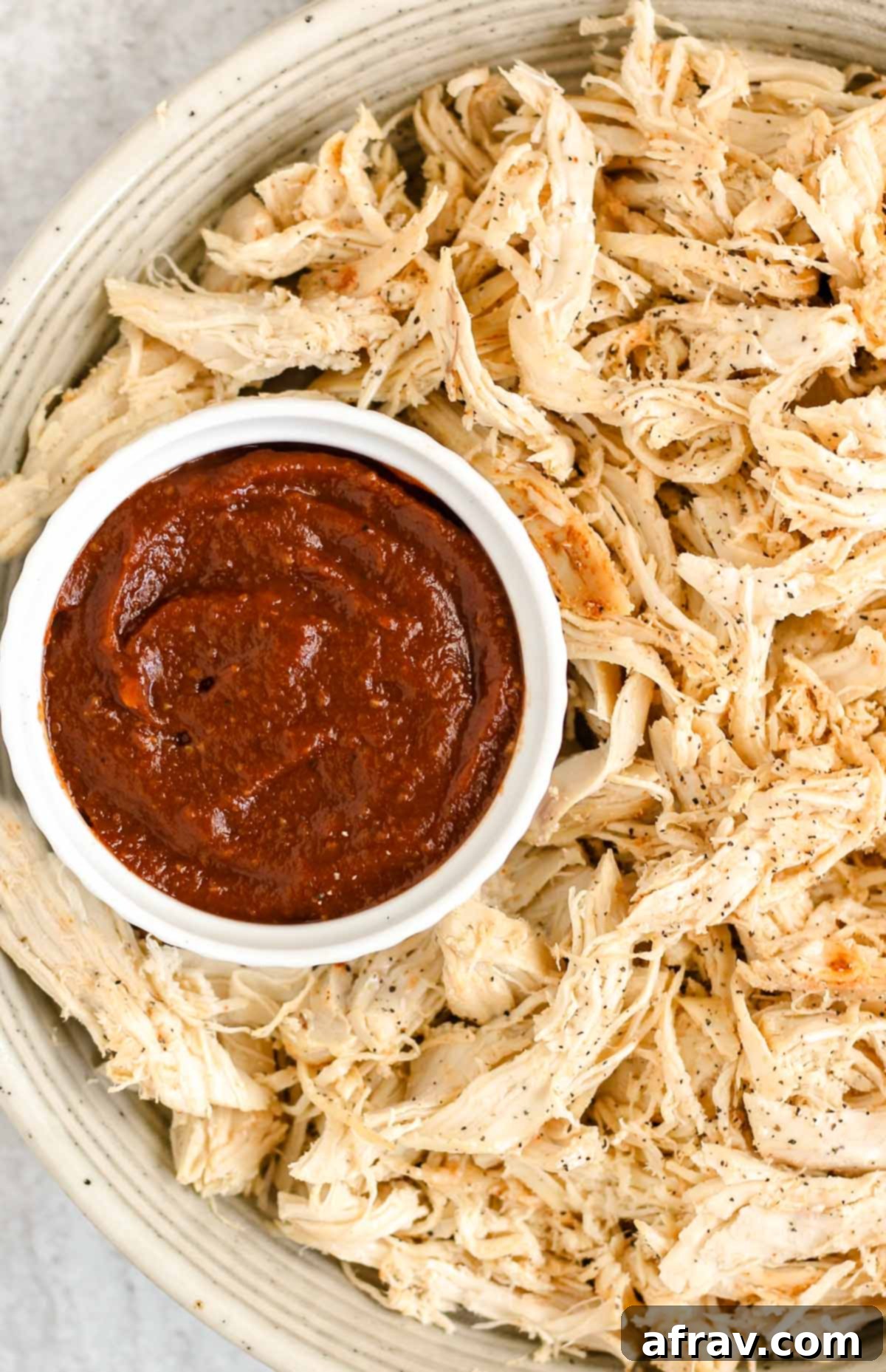 Delicious Whole30 Paleo BBQ Sauce 7 Serving bowl of pulled chicken with a side dish of Whole30 BBQ sauce.