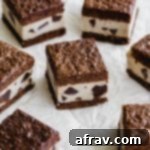 Brownie ice cream sandwiches arranged on a crumpled sheet sheet of parchment paper, invitingly presented.