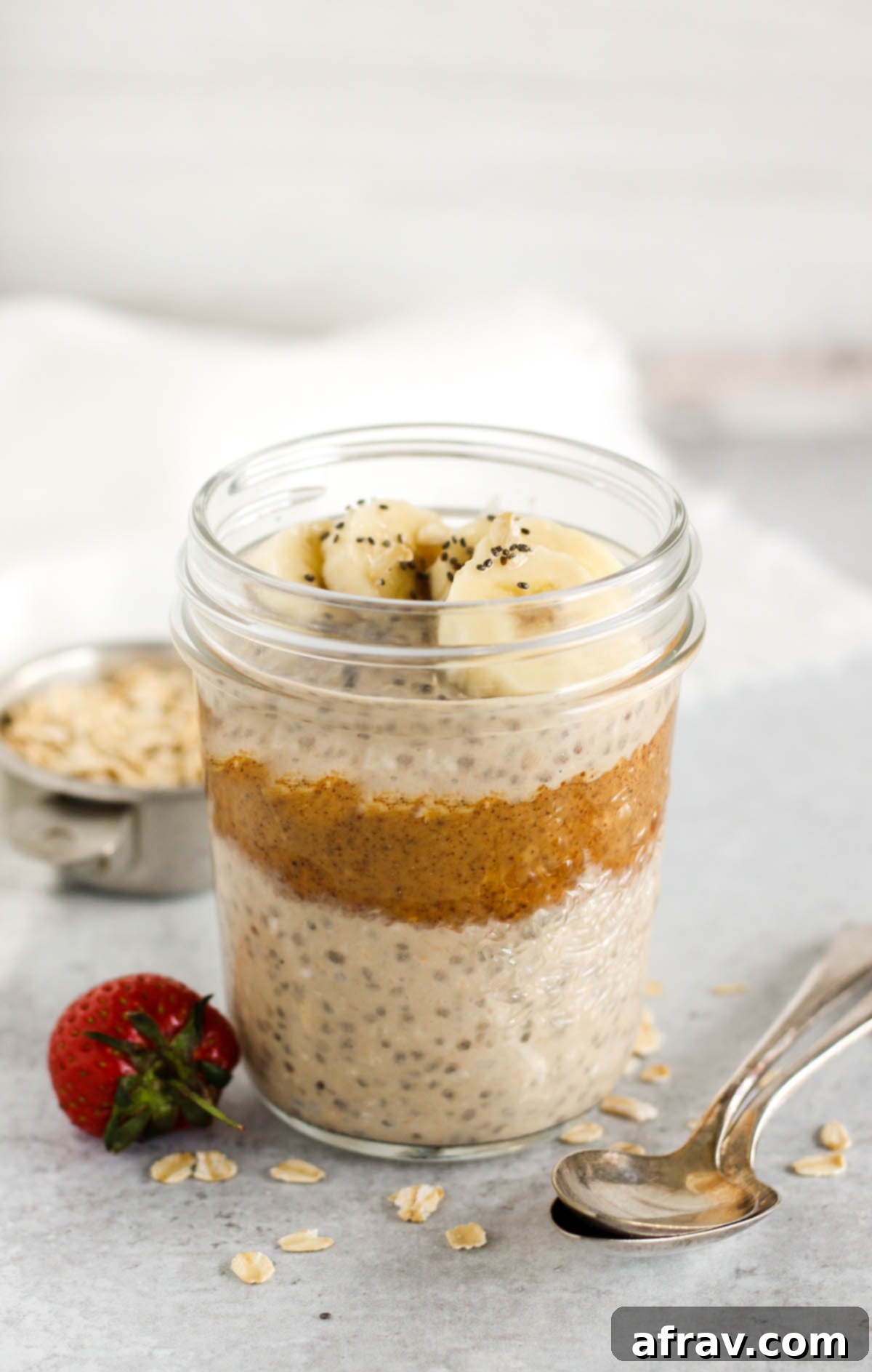 Overnight oats topped with sliced banana and chia seeds in a mason jar.