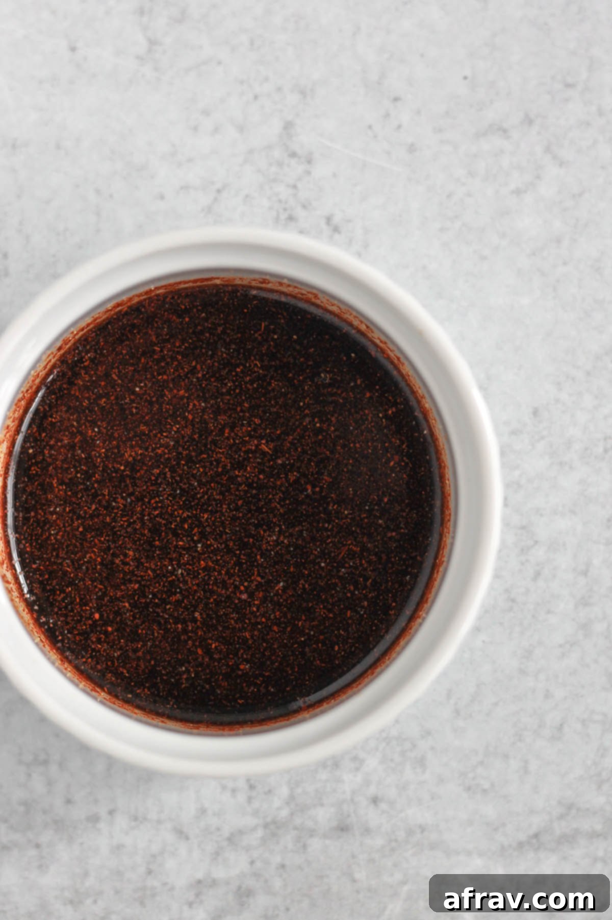 Dark red sauce in a small ramekin.
