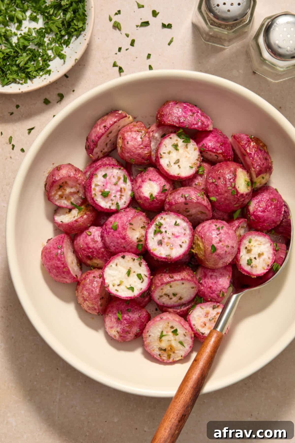 Radishes served in a bowl and garnished with chopped parsley.