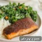 Perfectly Crispy Air Fryer Salmon 2 Up close view of a piece of air fryer salmon plated with a green salad and rice.