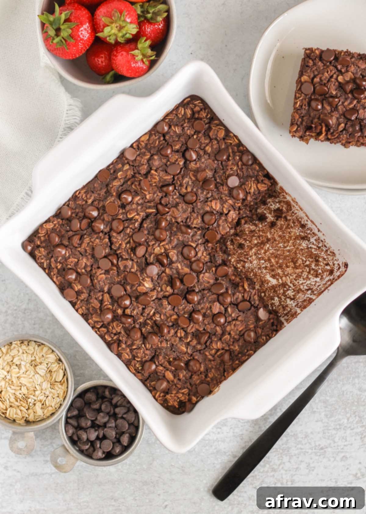 chocolate baked oats in a baking dish with a square piece cut out of the oats.