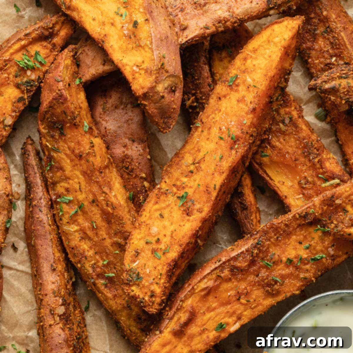 Effortless Air Fryer Side Dishes 18 Close up view of air fryer sweet potato wedges arranged on brown parchment paper, showing their perfectly cooked texture.