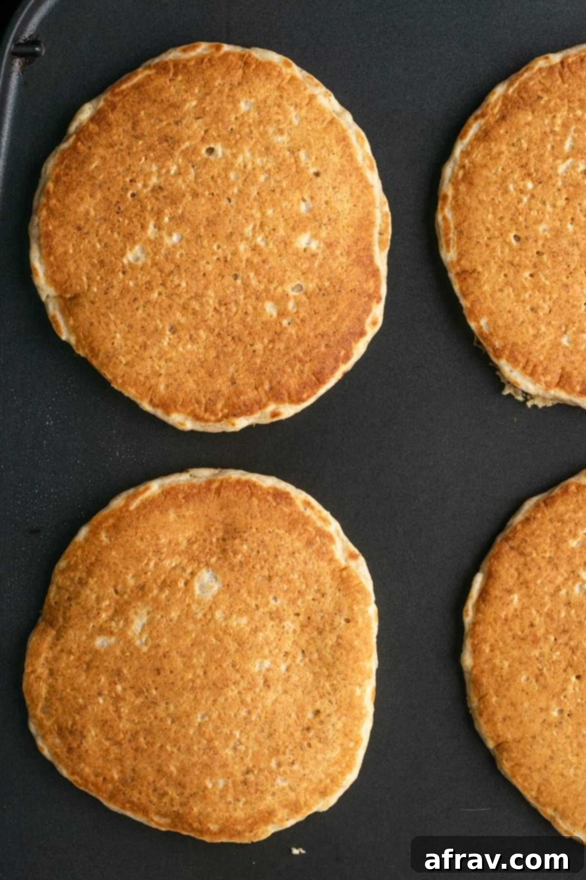 Fluffy Oat Flour Pancakes 5 Cooked pancakes on a griddle.