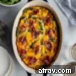 Overhead view of butternut squash quiche in an oval baking dish with a bowl of salad on the side.