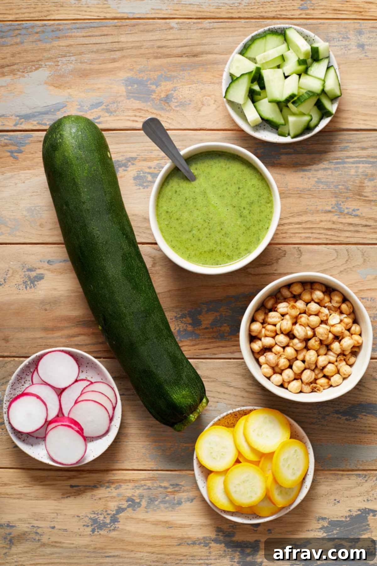 Zoodle Bowls 3 Ingredients to make zucchini noodle bowls arranged on a wooden table.