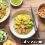 Zoodle Bowls 7 Overhead view of zucchini noodle bowls arranged on a wooden table.