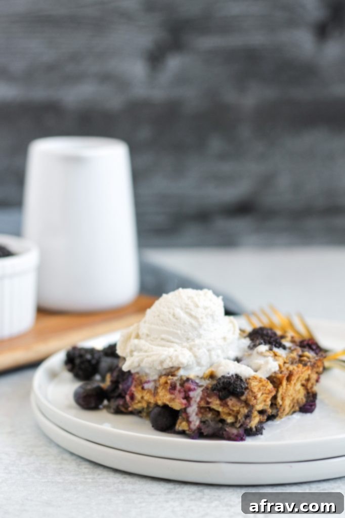 A beautiful slice of baked berry oatmeal, golden brown with visible berries, ready to be topped with cream