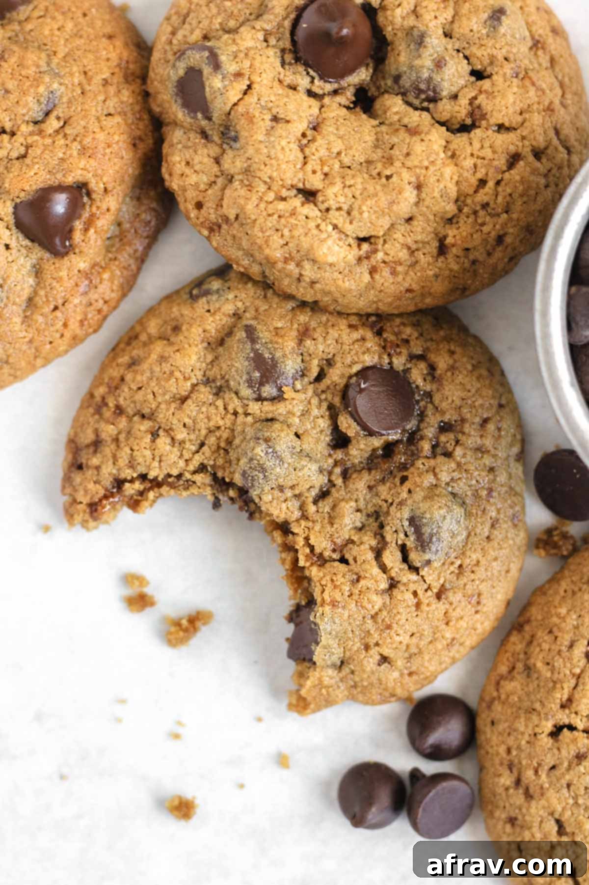 Close-up image of a oat flour chocolate chip cookie with a bite taken out of the cookie.