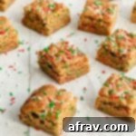 Christmas blondies cut into squares and arranged on a sheet of parchment paper.