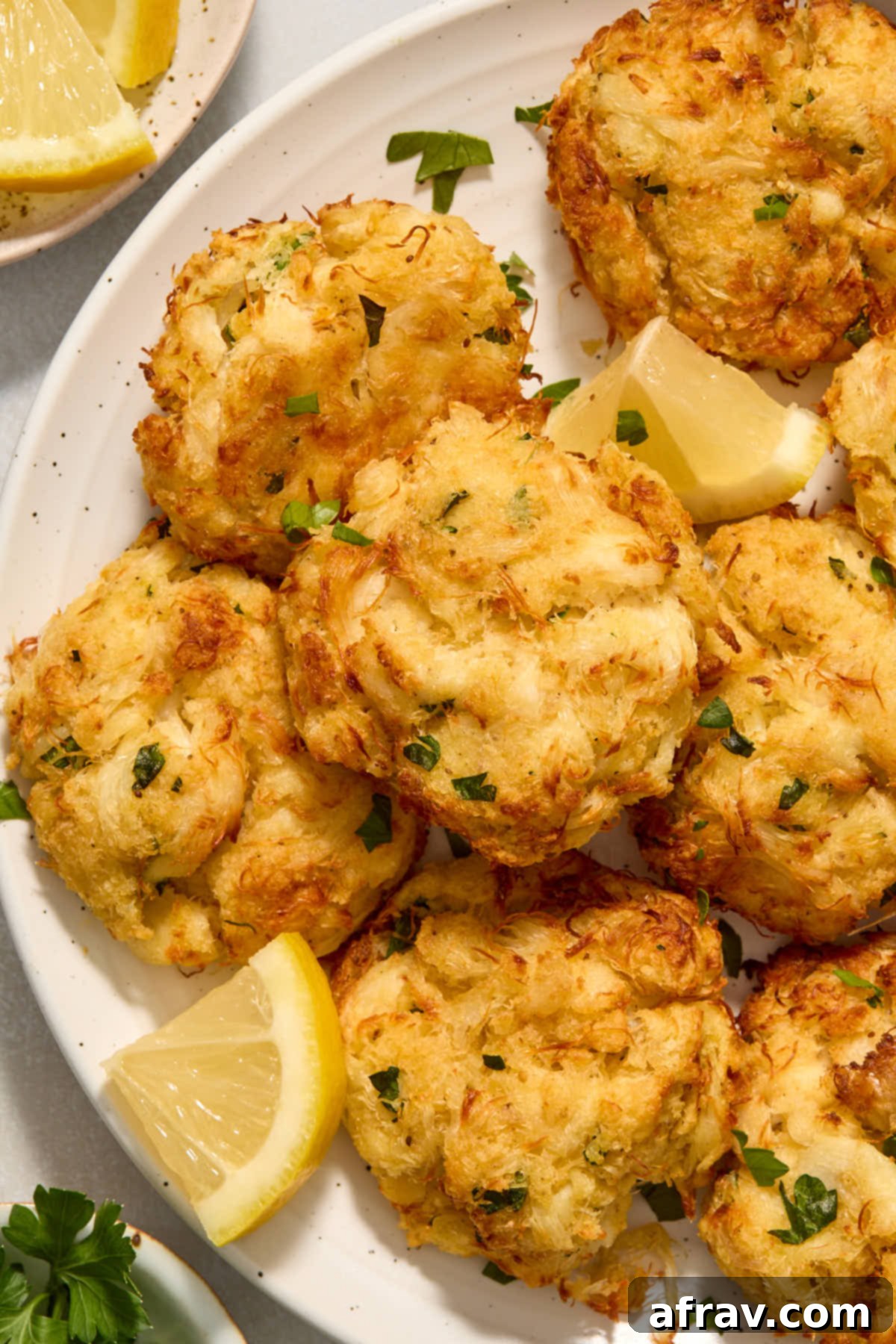Crispy and Delicious Air Fryer Crab Cakes 8 Platter of golden air-fried crab cakes garnished with fresh lemon slices, ready to be served.
