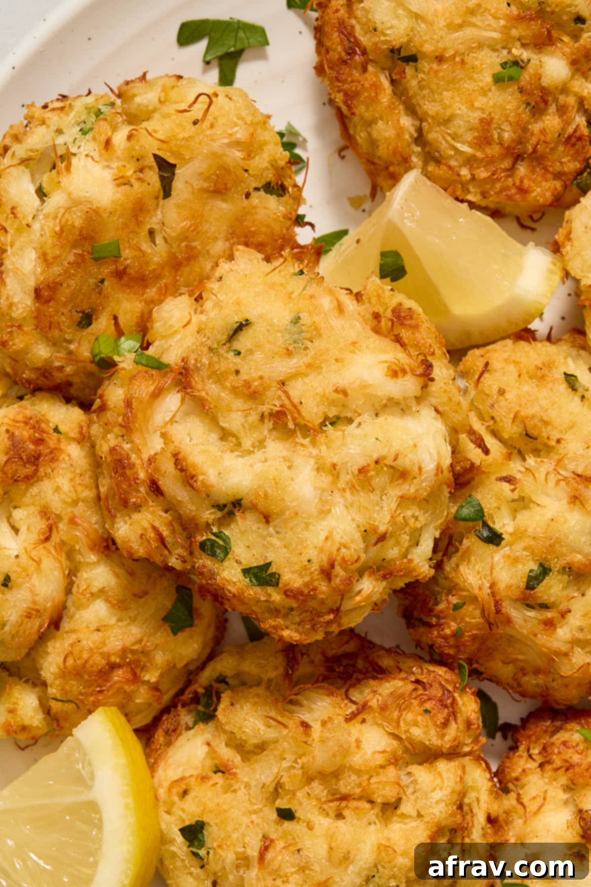 Crispy and Delicious Air Fryer Crab Cakes 9 Close up of a single air-fried crab cake with chopped parsley on top, highlighting its texture.