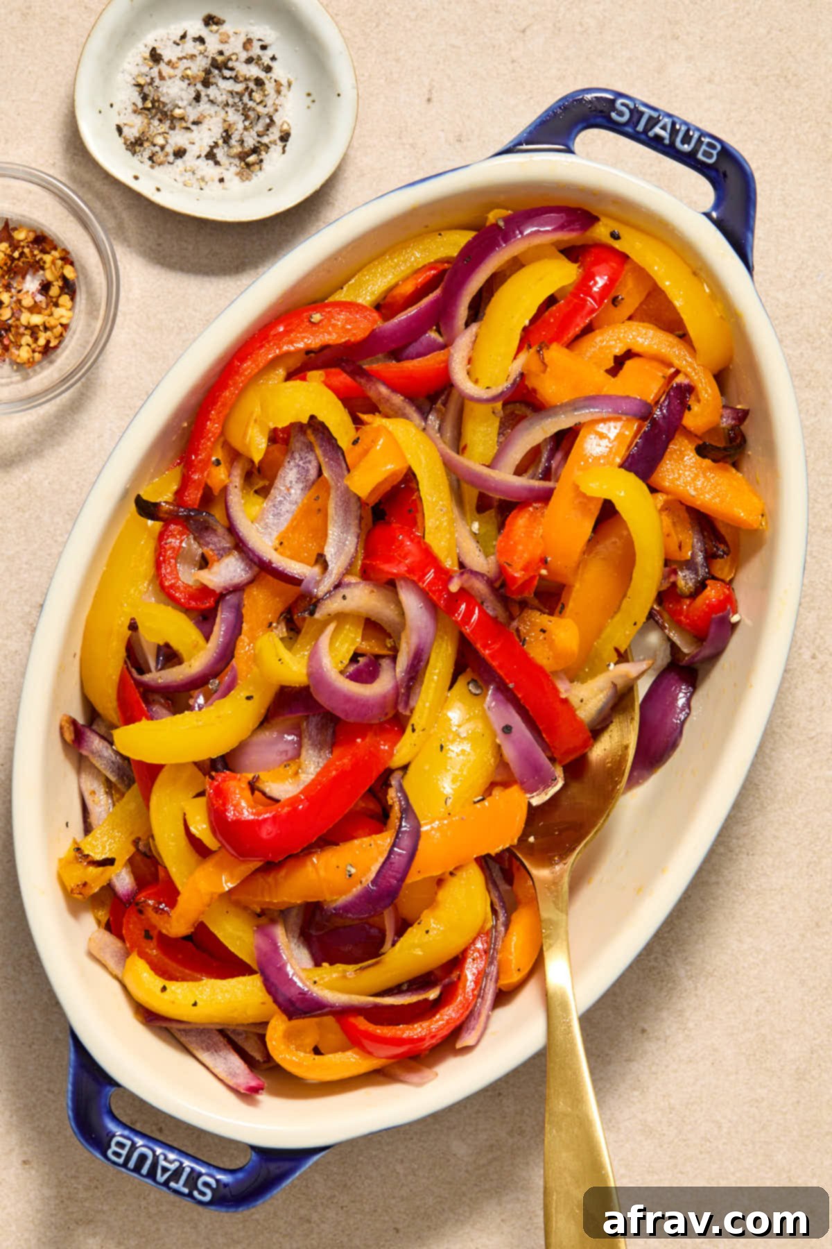 Golden Air-Fried Peppers and Onions 2 Peppers and onions served in an oval dish with seasonings on the side.