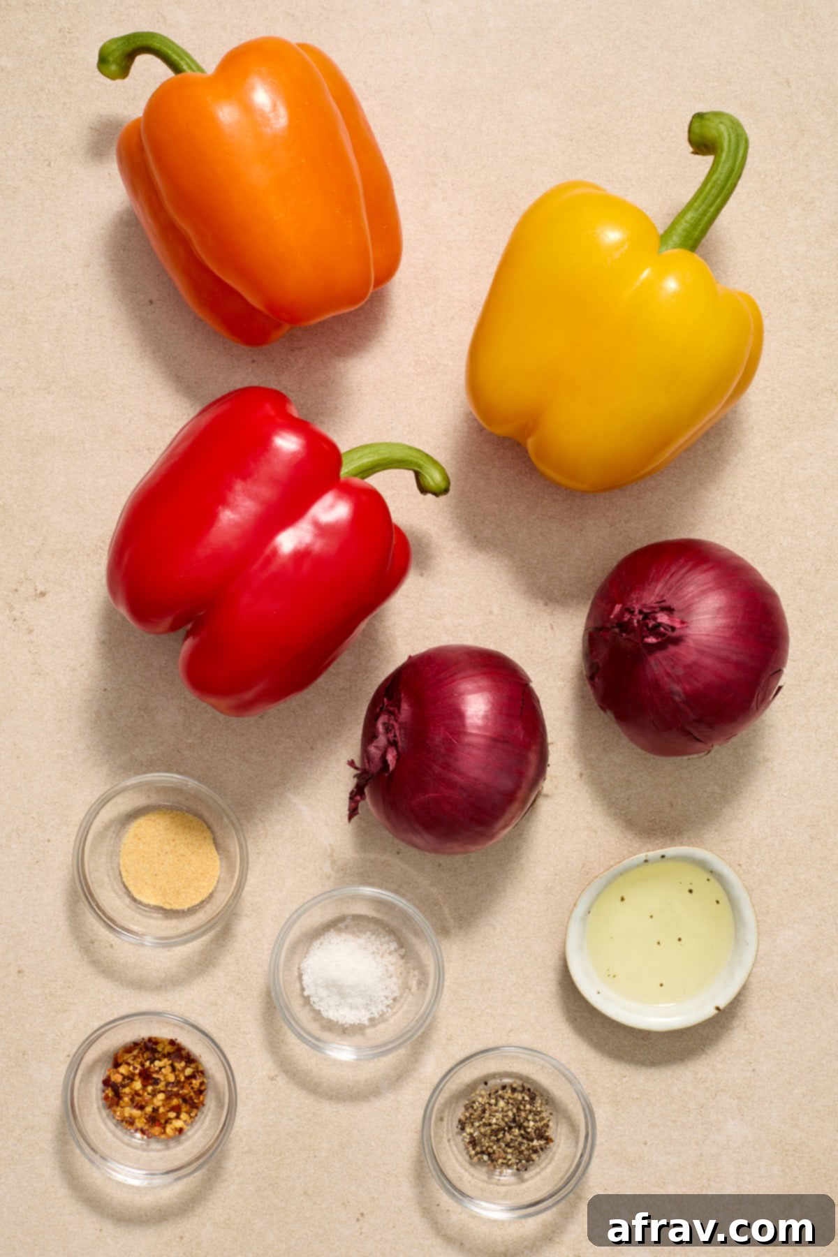 Golden Air-Fried Peppers and Onions 3 Ingredients to make air fryer peppers and onions arranged individually on a work surface.